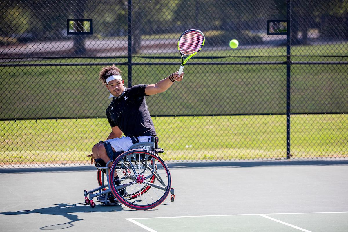 一名轮椅网球运动员反手击球.
